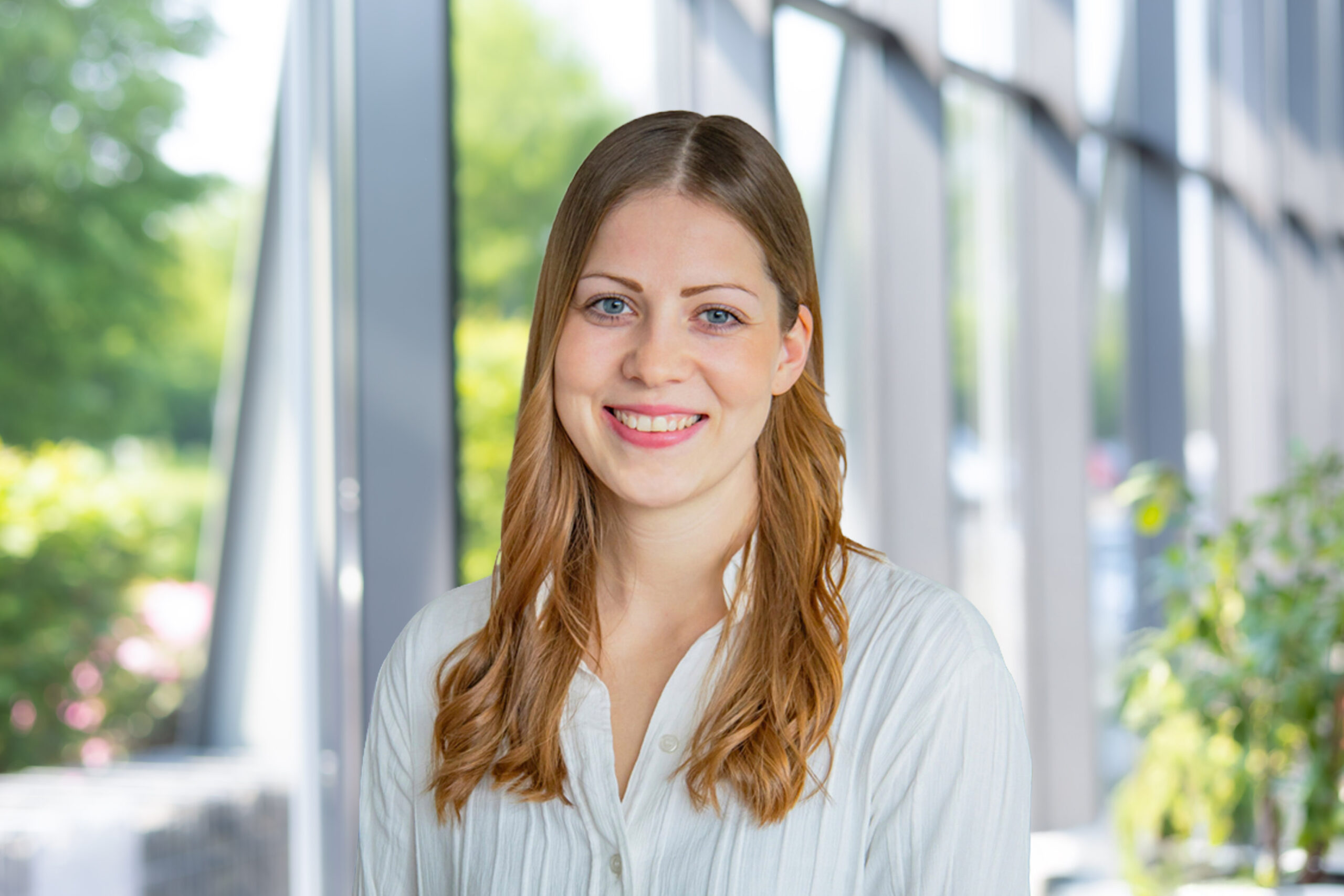 Janina Bauken, Project Assistant Visbek Industrie, portrait in front of a glass facade