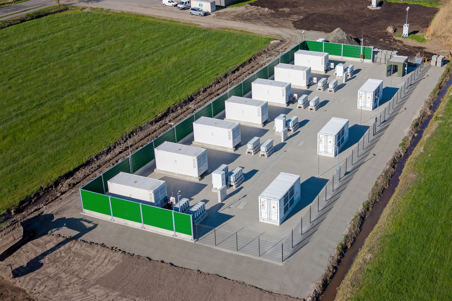 Aerial view of a battery storage facility with containers and fencing.
